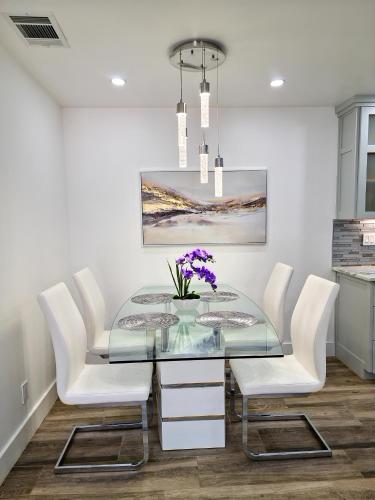 a dining room with a glass table and white chairs at Cozy modern house - Near SXSW and other events in Austin