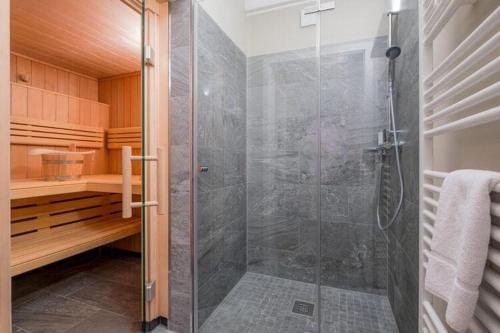 ein Bad mit einer Dusche und einer Glastür in der Unterkunft Cottages, turf house in Torfhaus