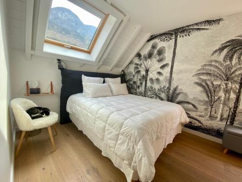 1 dormitorio con cama, ventana y silla en Appartement Bel Azur, en Veyrier-du-Lac