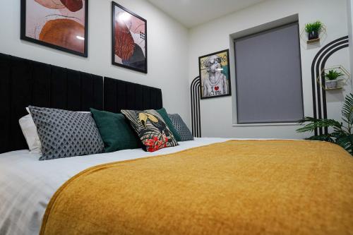 a bedroom with a bed with a yellow blanket on it at Spacious Luxury Apartment in Stevenage, Sleeps 6, with Free Parking, and Free Wi-Fi in Stevenage