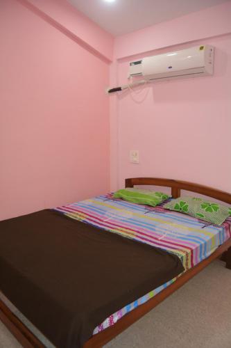 Cama en habitación con pared de color rosa en chill out home morjim en Morjim