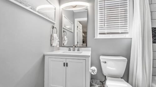 a bathroom with a sink and a toilet and a mirror at Blue Neptune at 5313 Sunset Avenue by Nautical Properties Vacation Rentals in Panama City Beach