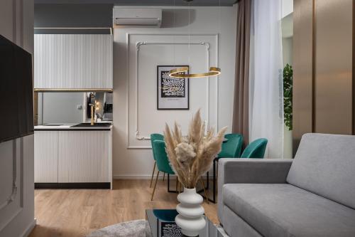 uma sala de estar com um sofá e cadeiras verdes em Dream Fiumara Apartments em Rijeka