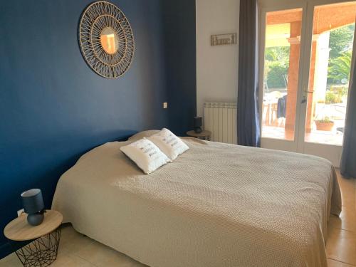 1 dormitorio con 1 cama grande y pared azul en Les Palmiers, en Le Muy