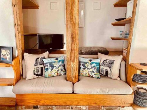 - un canapé avec des oreillers dans le salon dans l'établissement The Nutshell, à West Mersea