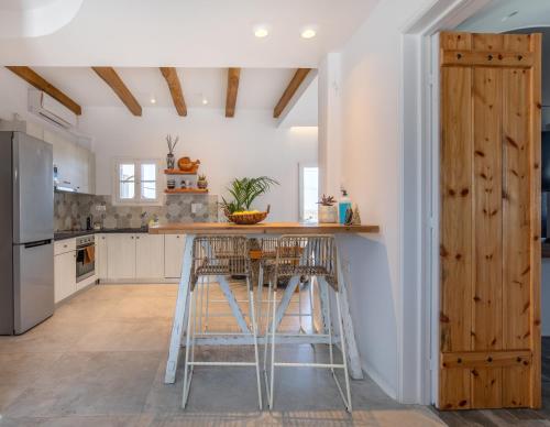 a kitchen with a counter and stools in it at KaLanAn Luxury Apartment in Aggelika