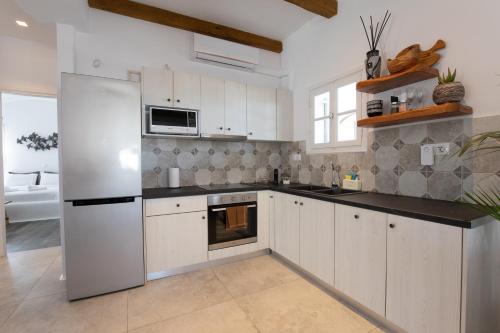 a kitchen with white cabinets and a white refrigerator at KaLanAn Luxury Apartment in Aggelika