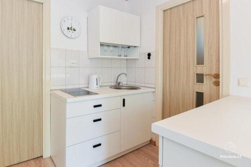 a white kitchen with a sink and a counter at RAMYBĖS OAZĖ 2 in Šventoji
