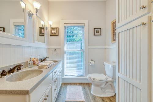 La salle de bains est pourvue de toilettes, d'un lavabo et d'une fenêtre. dans l'établissement Monroe Manor Inn, à South Haven