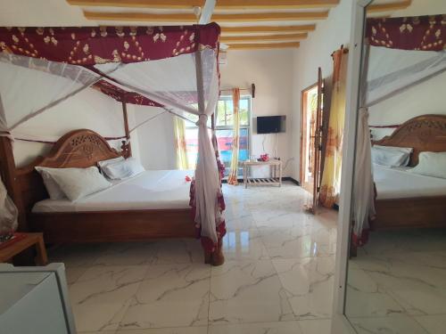 a bedroom with two beds and a mirror at BARIDI VILLA in Zanzibar City