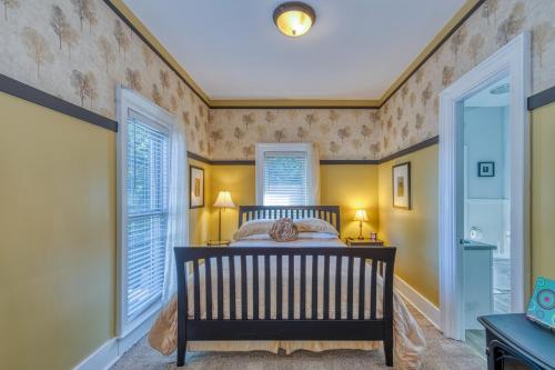 a bedroom with a crib in a room with windows at Monroe Manor Inn in South Haven