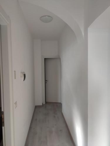 an empty hallway with a door in a white room at Casa Levante in Urbisaglia