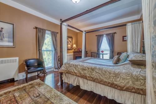 a bedroom with a large bed and a chair at Monroe Manor Inn in South Haven