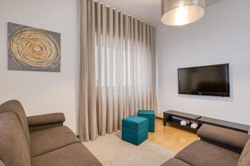 a living room with a couch and a flat screen tv at Spacious House in Porto for family and friends in Maia