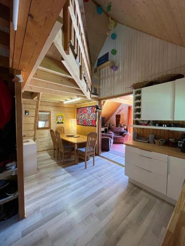 une cuisine et un salon avec une table et des chaises dans l'établissement Chalet authentique, à La Salette-Fallavaux
