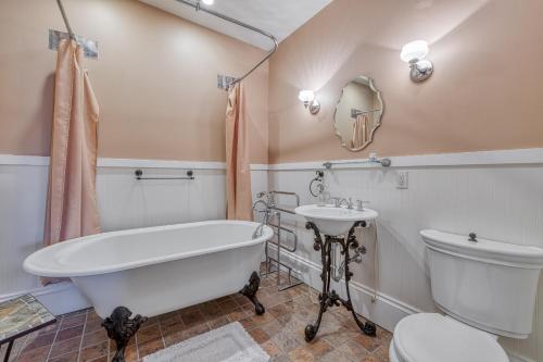 a bathroom with a tub and a toilet and a sink at Monroe Manor Inn in South Haven