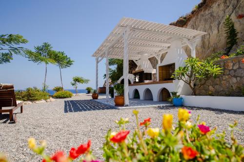 a garden with a pavilion and flowers in the foreground at Anatoli Traditional Villa in Archangelos