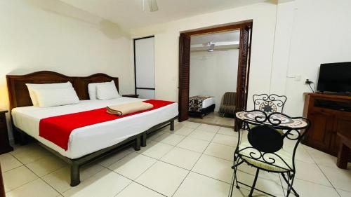 a bedroom with a bed and a tv and a chair at Hotel B&B - 5th Avenue in Playa del Carmen