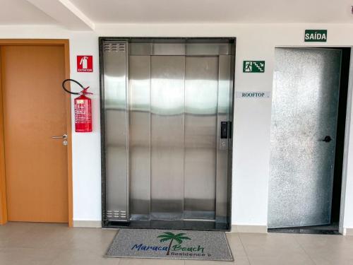 un ascensor de metal en un edificio con puerta en Flat alto padrão próximo ao mar de Maracaípe, en Ipojuca