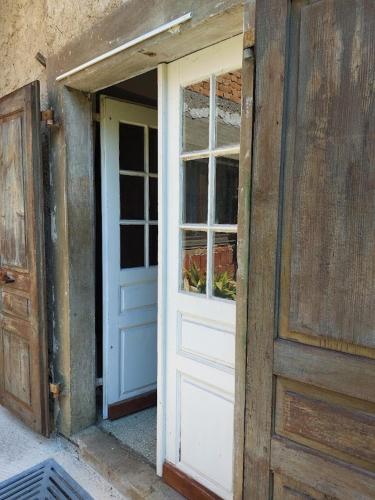 an open door of a house with a window at Domačija pri Ivankovih in Osilnica
