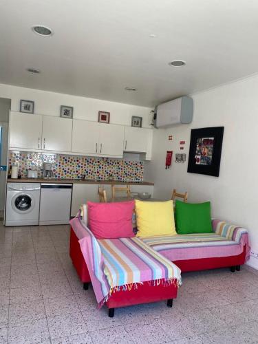 uma sala de estar com um sofá e uma cozinha em Stay Porto Côvo II em Porto Covo