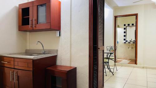 a kitchen with a sink and cabinets and a dining room at Hotel B&B - 5th Avenue in Playa del Carmen