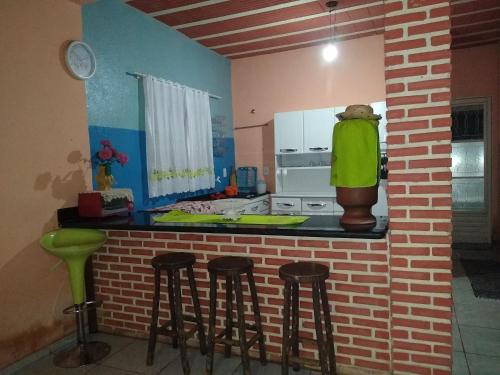 a kitchen with a counter and some bar stools at Sítio Descanso E Natureza Igarapé - 20km Inhotim in Igarapé