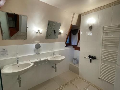 La salle de bains est pourvue de 2 lavabos et d'un miroir. dans l'établissement Le prieuré des fontaines, à Les Préaux