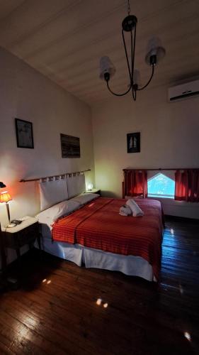 ブエノスアイレスにあるBoutique Hotel Casa Rugantinoのベッドルーム1室(赤毛布付きの大型ベッド1台付)