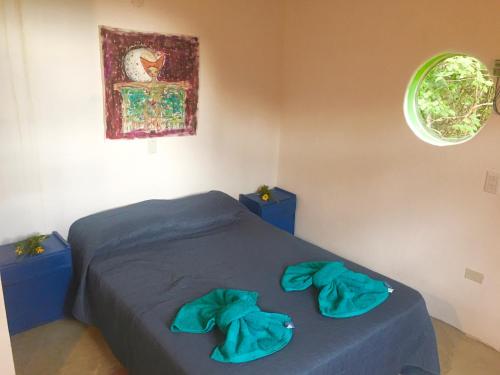 1 dormitorio con cama con sábanas azules y ventana en Casa de montaña placentera en la naturaleza con vista espectacular en Traslasierra en Córdoba
