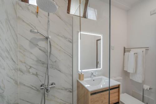 a bathroom with a shower and a sink and a mirror at Villa Beach Club in Santa Cruz