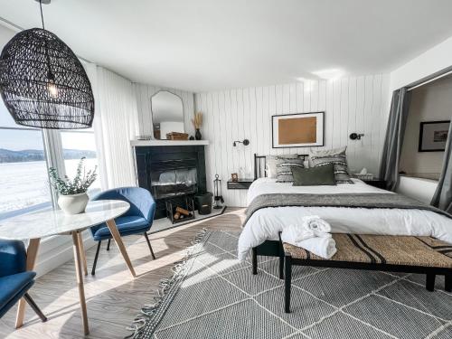 a bedroom with a bed and a table and chairs at Les Lofts du Lac des Sables by Gestion ELITE in Sainte-Agathe-des-Monts