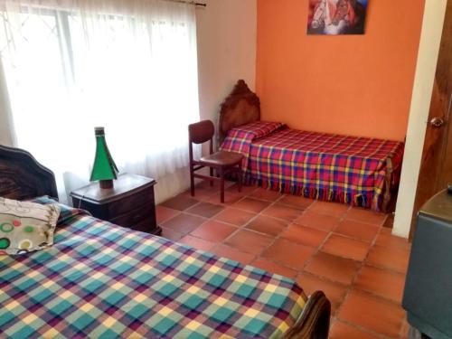 - une chambre avec 2 lits, une table et une fenêtre dans l'établissement Casa de Campo Finca el Paraiso, à Zipacón