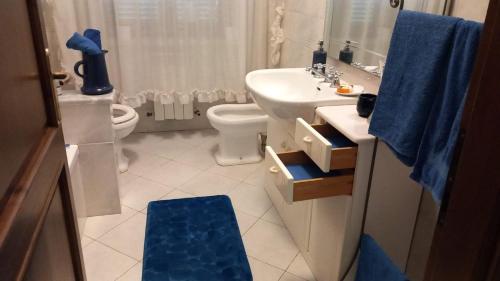 La salle de bains est pourvue d'un lavabo blanc et de toilettes. dans l'établissement Casa Giovanna, à Venturina Terme