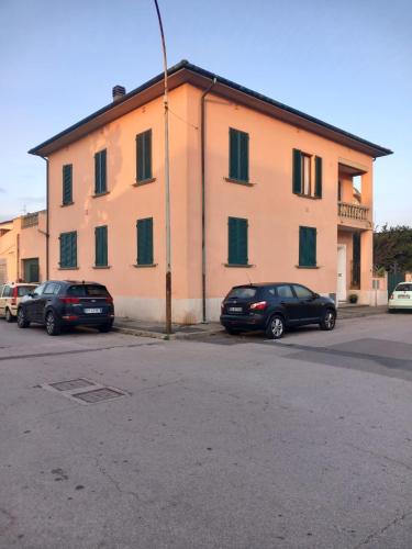 two cars parked in front of a large building at Casa Giovanna in Venturina Terme