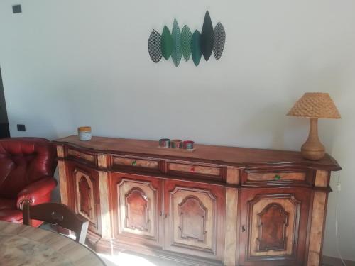 a wooden cabinet in a room with a lamp and a table at Casa Giovanna in Venturina Terme