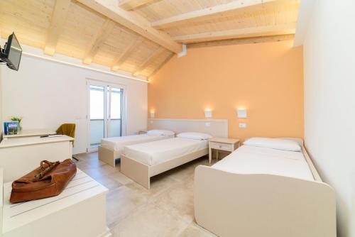 a bedroom with two beds and a desk with a bag at L'Antico Portone B&B in Palinuro