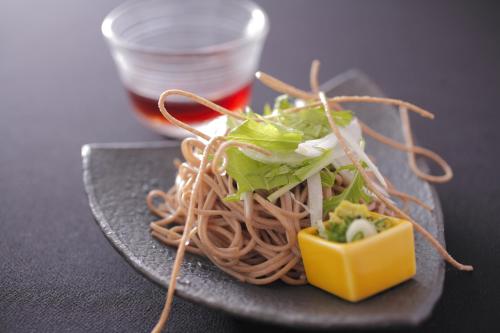 a plate of noodles with a salad and a yellow cube at Jukaitei in Kyotango