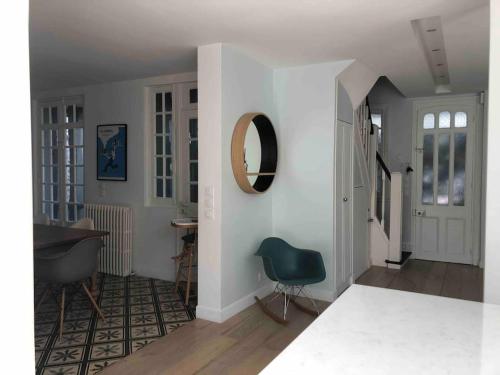 - un salon avec une chaise bleue et un miroir dans l'établissement Villa Le Nid, à Deauville
