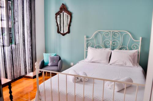 a bedroom with a white bed and a blue wall at A Casa do Chafariz in Ribeira Grande