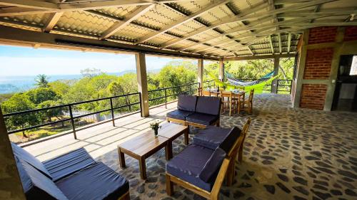 Un balcón con sillas, una mesa y una hamaca. en Villa Ometepe en Mérida