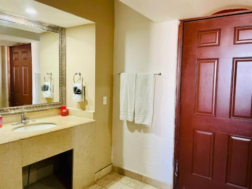 baño con lavabo y puerta roja en Luxury’s house, en Puerto Peñasco