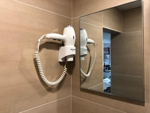 ein Telefon hängt an einer Wand in einem Badezimmer in der Unterkunft Pé do Castelo Casinha in Tomar
