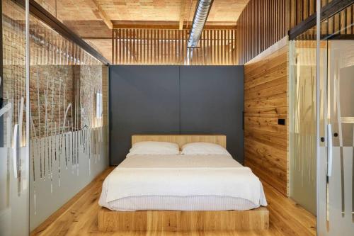 - une chambre avec un grand lit et des murs en bois dans l'établissement CAN JAUME 1921 Plaza Perpinyà ,21, à Banyoles