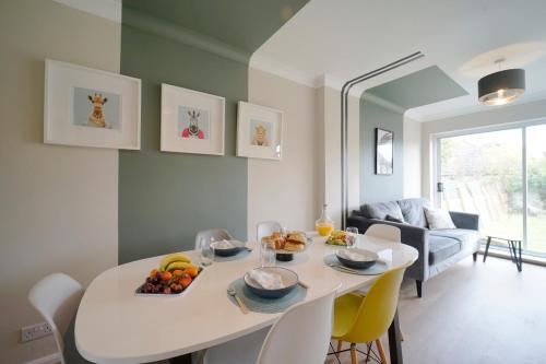 Il dispose d'une cuisine et d'un salon avec une table et des chaises blanches. dans l'établissement Stunning luxury 3 bed house with garden in North Leeds, à Moortown