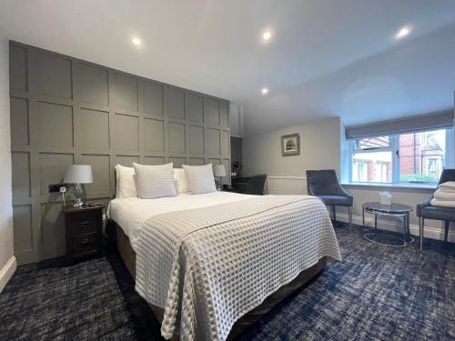 a bedroom with a large bed and a chair at Cantley House Hotel - Wokingham in Wokingham