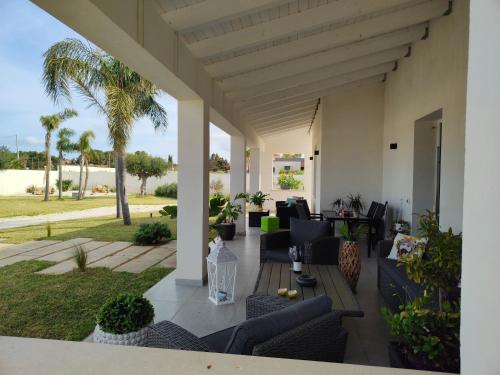 a patio with couches and chairs and palm trees at Suite12 in Marsala