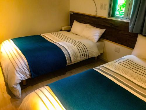 1 dormitorio con 2 camas y ventana en Niruyakanaya BISE - Vacation STAY 68196v en Bise