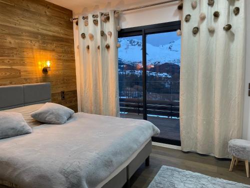 ル・デヴォリュイにあるchalet KAMS de luxe devoluyのベッドルーム1室(ベッド1台、大きな窓付)