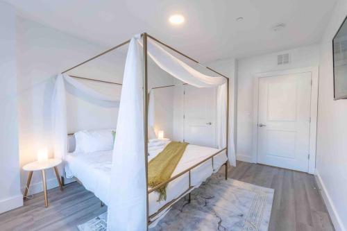 a bedroom with a bed with a canopy at 2 bedroom 2 bath Suite, Near American Dream and The Airport, Free Parking, King Bed and 2 Queen Beds, Washer and Dryer in Orange